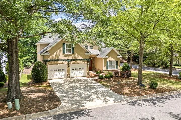 This beautiful residence features a welcoming exterior, an attached garage, and a spacious driveway.