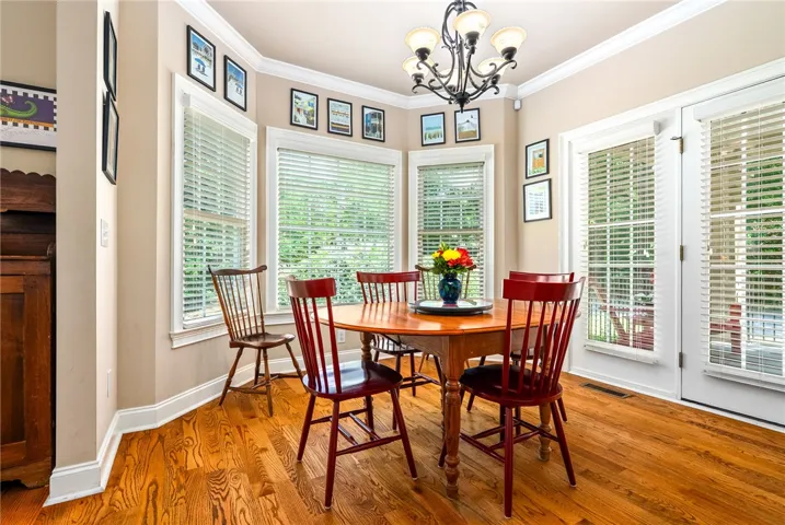 This bright dining area features ample natural light and rich wood flooring.
