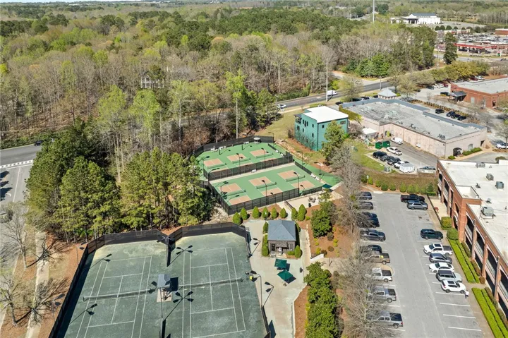 This aerial view showcases a vibrant community with recreational courts and ample parking.