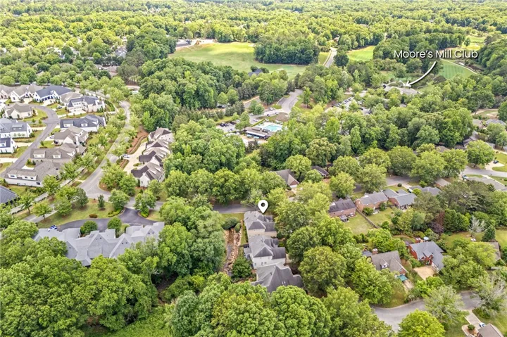 An aerial perspective reveals a vibrant neighborhood nestled among lush trees and community amenities.