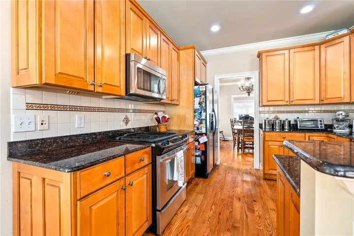 This spacious kitchen offers ample cabinetry, modern appliances, and beautiful hardwood floors.