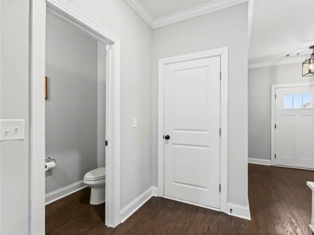 This interior hallway features rich hardwood flooring and classic white trim, creating an elegant transition.