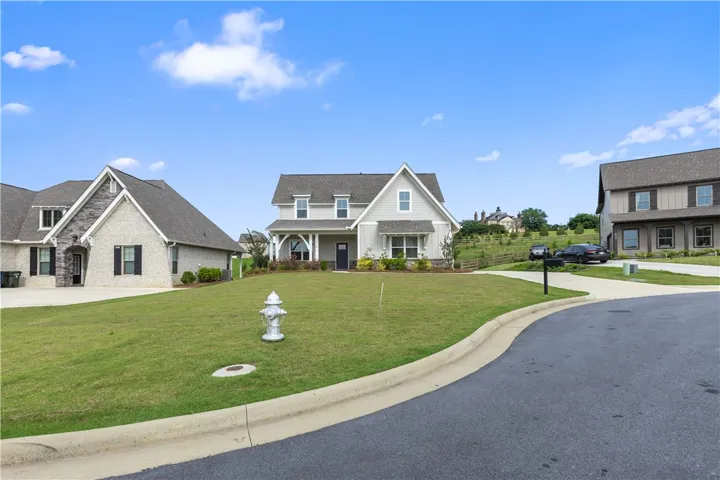 This charming home features a lovely front yard, a classic gable roof, and a welcoming front door.