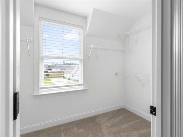 This spacious walk-in closet offers ample storage and natural light, enhancing its functional appeal.