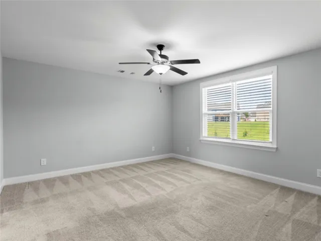 This spacious room offers comfort and versatility, featuring ample natural light and a neutral palette.