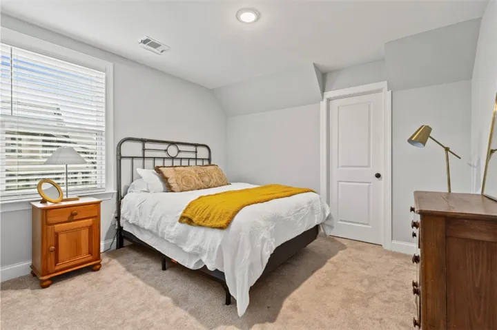 This cozy bedroom features plush carpeting and abundant natural light, offering a tranquil retreat.