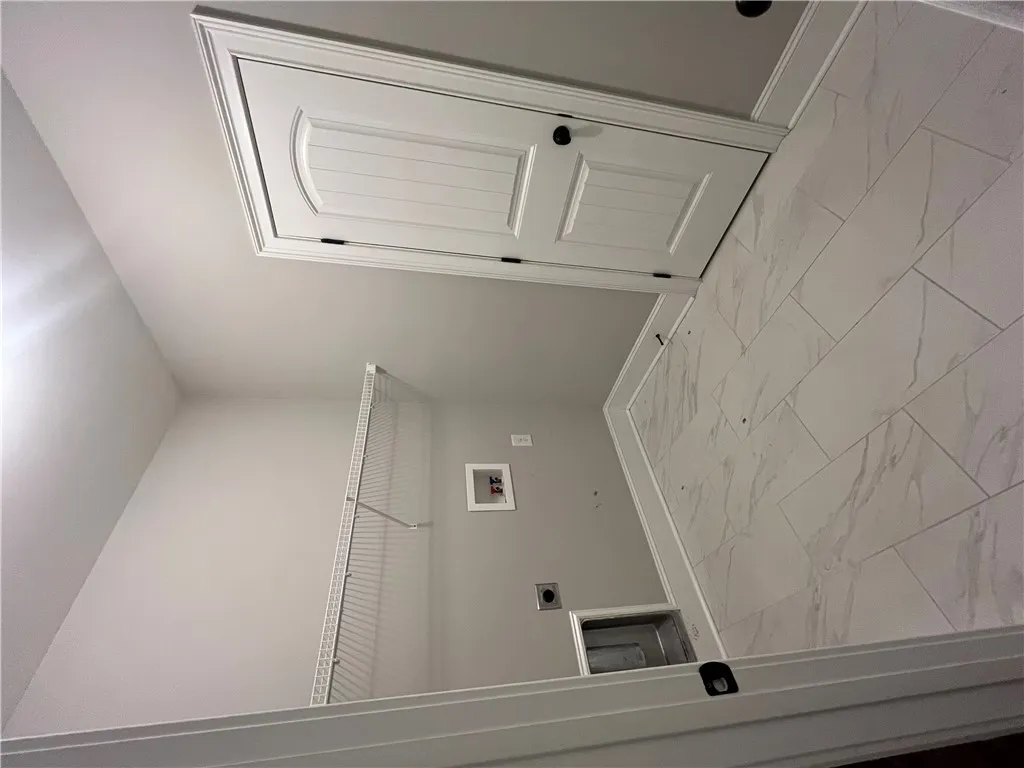 This laundry room features durable tile flooring, providing a practical and clean space for household tasks.