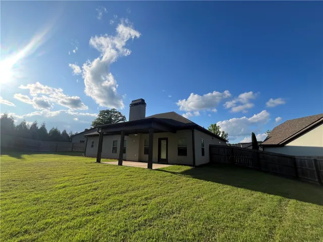 This residence features a fenced backyard with a covered patio, perfect for outdoor enjoyment.