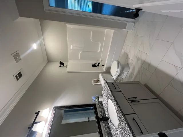 This bathroom offers a clean aesthetic with practical fixtures and a vanity for everyday convenience.