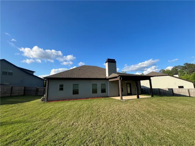 This spacious backyard offers a private oasis with a covered patio perfect for outdoor living.