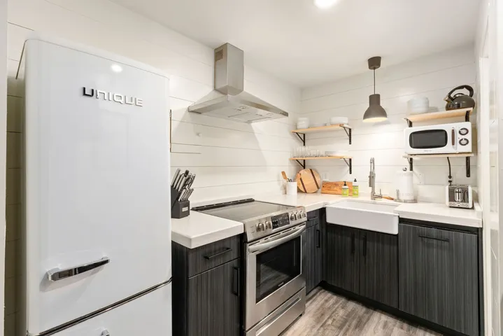 This modern kitchen features crisp white walls and sleek dark cabinetry, perfect for any culinary enthusiast.