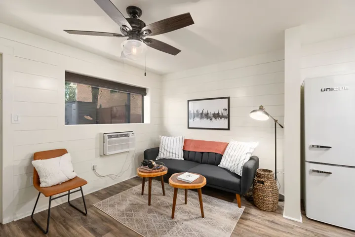 Bright and inviting living area with a cooling unit and wood flooring.