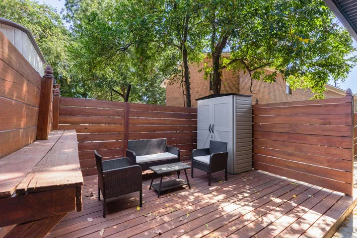 This spacious outdoor area features a wooden deck and privacy fencing, ideal for entertaining or relaxation.