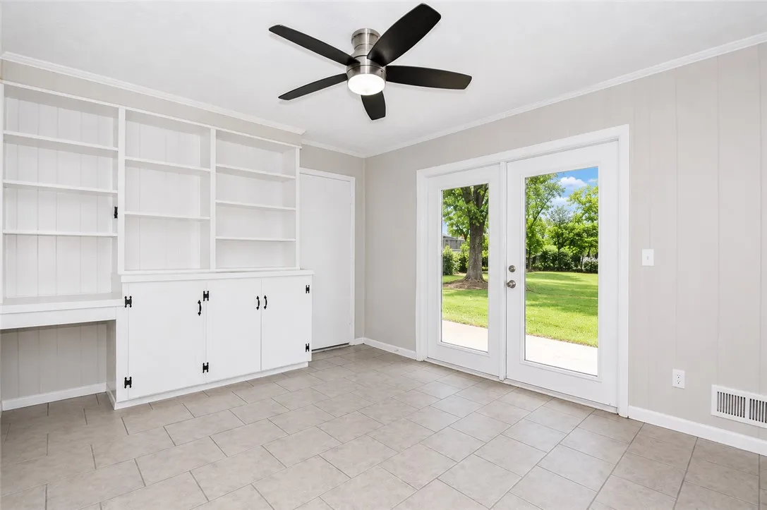 This versatile room features ample storage and offers direct access to the inviting backyard.