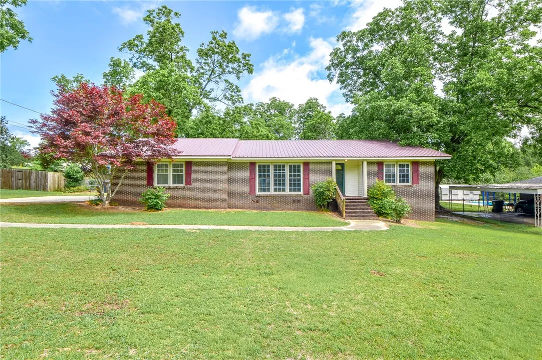 This charming brick home offers a verdant yard and a welcoming entrance.