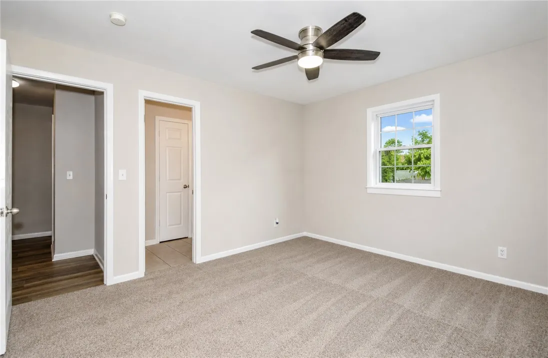 Bright and airy room with serene views of lush greenery through a charming window.