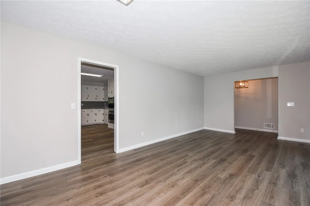 This spacious interior features seamless wood flooring, creating an inviting and cohesive living space.