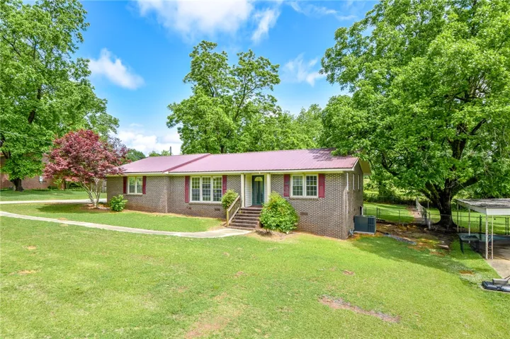 Charming residence with a sturdy brick exterior and a vibrant metal roof.