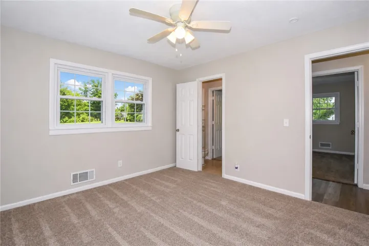 This spacious bedroom offers ample light and a comfortable, inviting atmosphere for relaxation.