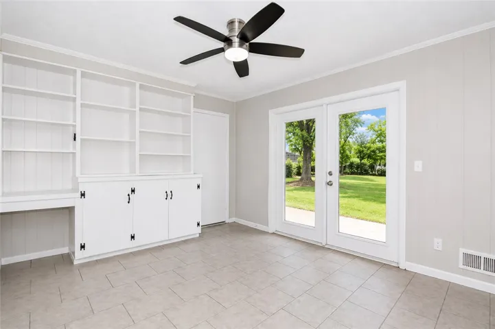 This versatile room features ample storage and offers direct access to the inviting backyard.
