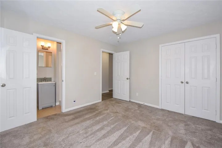 This spacious bedroom offers comfortable living with direct access to a private bathroom.
