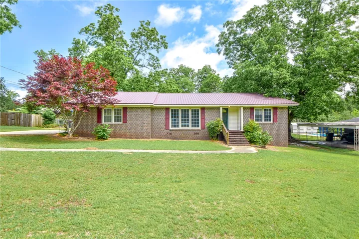 This charming brick home offers a verdant yard and a welcoming entrance.