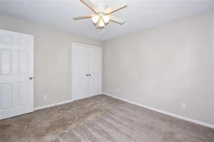 This spacious bedroom offers ample natural light and a comfortable atmosphere for rest and relaxation.