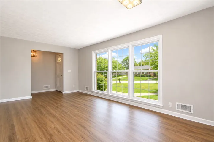 This bright living space features abundant natural light and beautiful wood flooring.