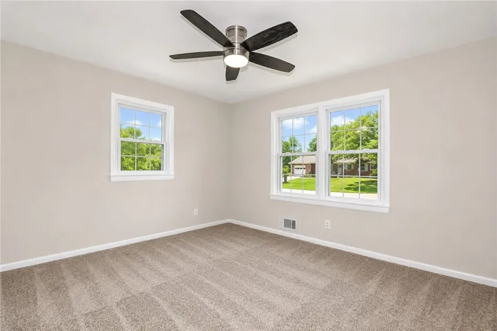 This bright and airy room offers comfort and ample natural light through its multiple windows.