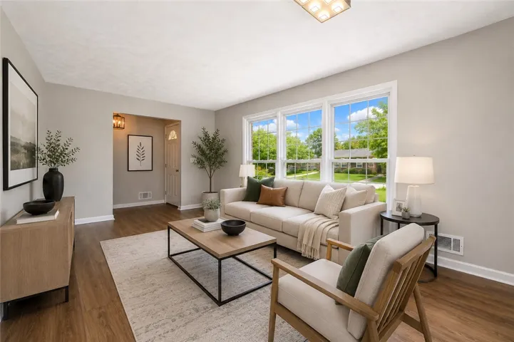 This bright living area features expansive windows, creating an inviting and airy atmosphere.