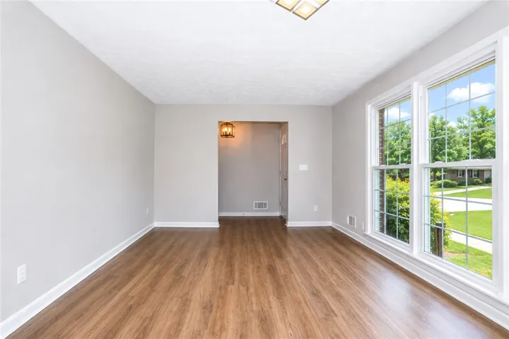 This bright room features beautiful hardwood floors and ample natural light through large windows.