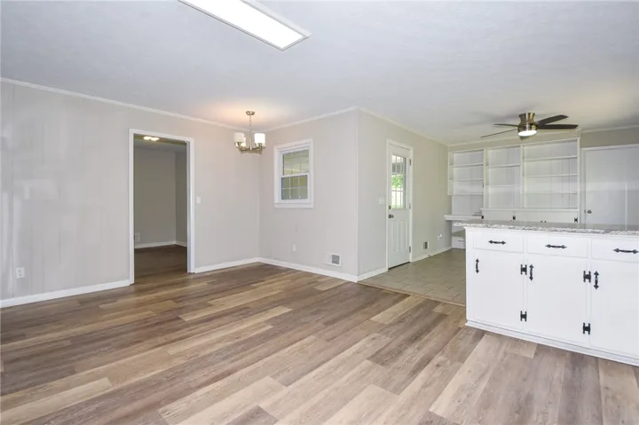 Bright and airy living area with elegant flooring and built-in shelving, ready for your personal touch.
