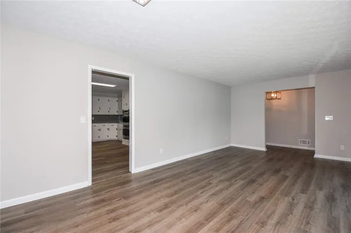 This spacious interior features seamless wood flooring, creating an inviting and cohesive living space.