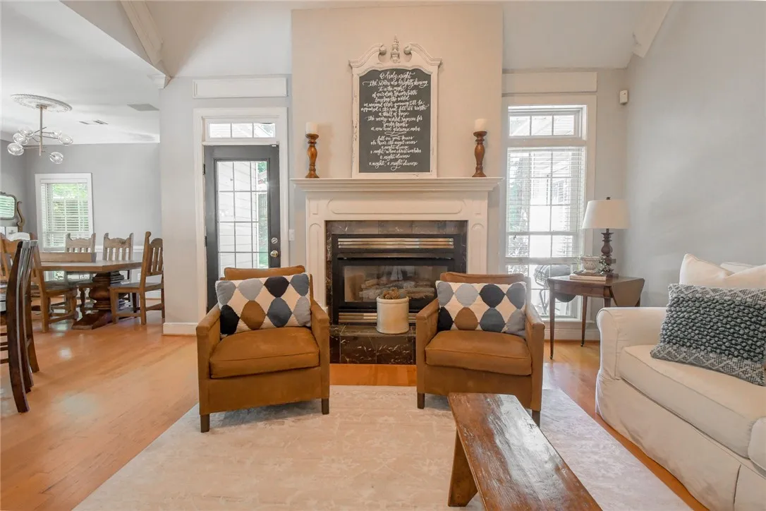 This inviting living area features a grand fireplace, perfect for cozy gatherings and a bright atmosphere.