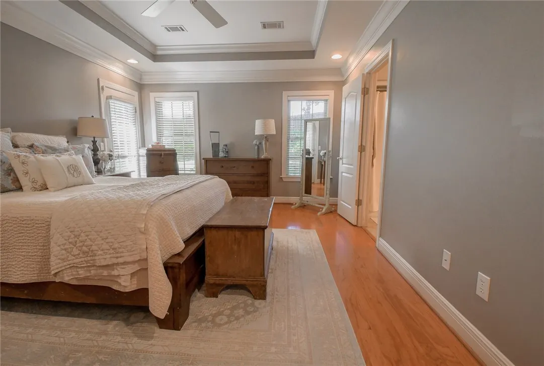 This spacious primary bedroom features hardwood flooring and bright windows.