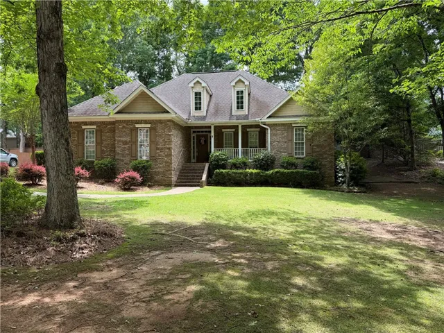 This classic brick residence features a welcoming front porch and mature landscaping.