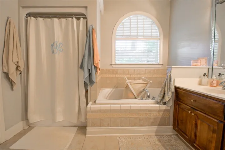 This bathroom features a deep soaking tub and a bright window, creating a serene personal retreat.