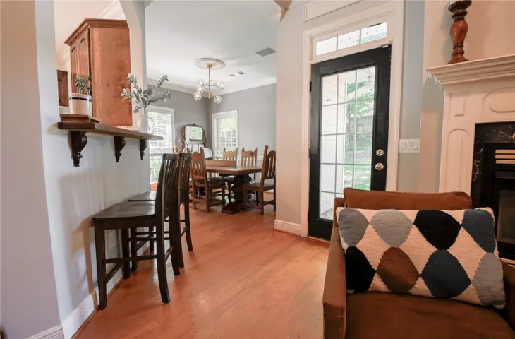 This inviting space features warm hardwood flooring, a charming fireplace, and abundant natural light.