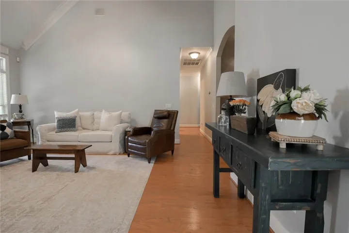 This inviting space features vaulted ceilings and rich wood flooring, ideal for comfortable living.
