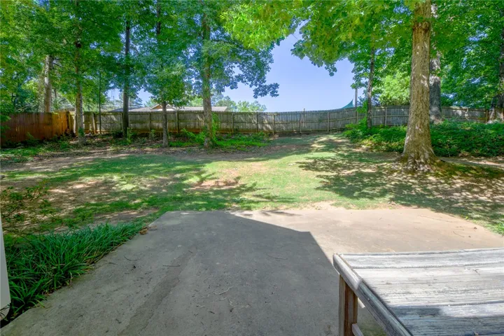This spacious private yard features a durable wood fence and ample green space.