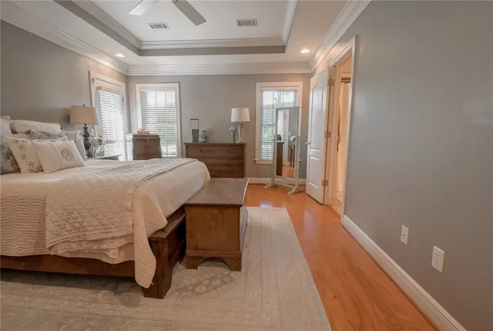 This spacious primary bedroom features hardwood flooring and bright windows.