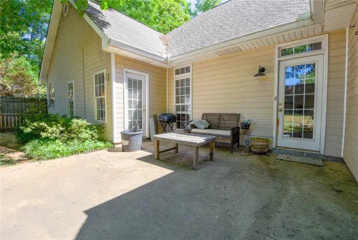 This concrete patio is perfect for outdoor dining and enjoying the surrounding lush greenery.