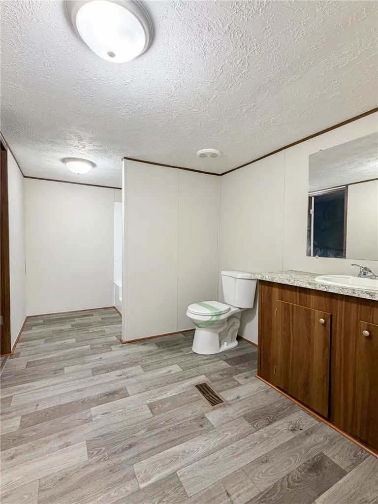 This bathroom features wood-look flooring and a functional vanity, perfect for daily routines.