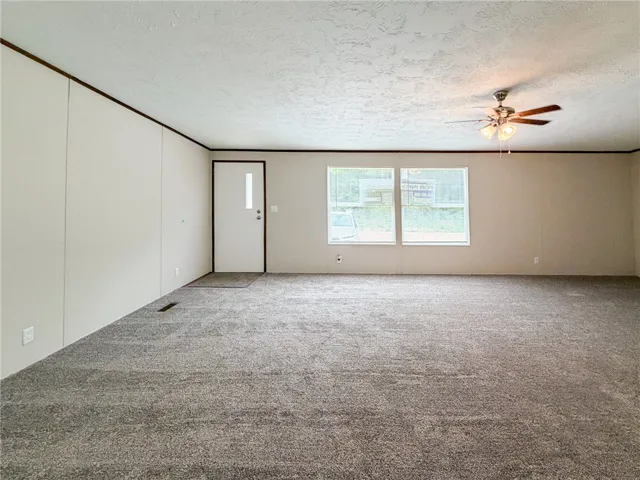 This expansive living space features plush carpeting, inviting comfort and style.