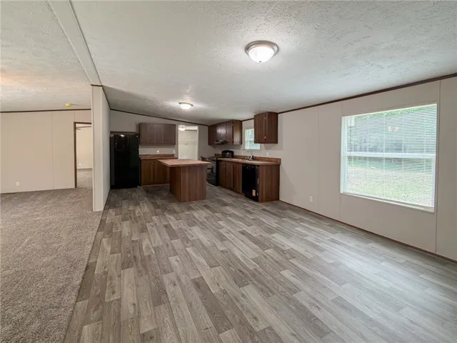 Open-concept living space with sleek flooring and a functional kitchen island awaits.