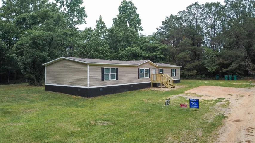 This charming residence is nestled among mature trees, offering a tranquil and private setting.
