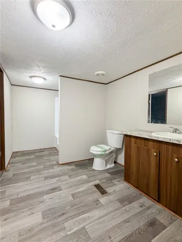 This bathroom features wood-look flooring and a functional vanity, perfect for daily routines.