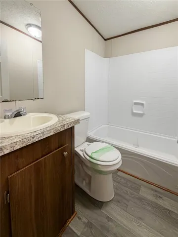 This functional bathroom features a clean tub, vanity, and toilet, offering practical comfort.