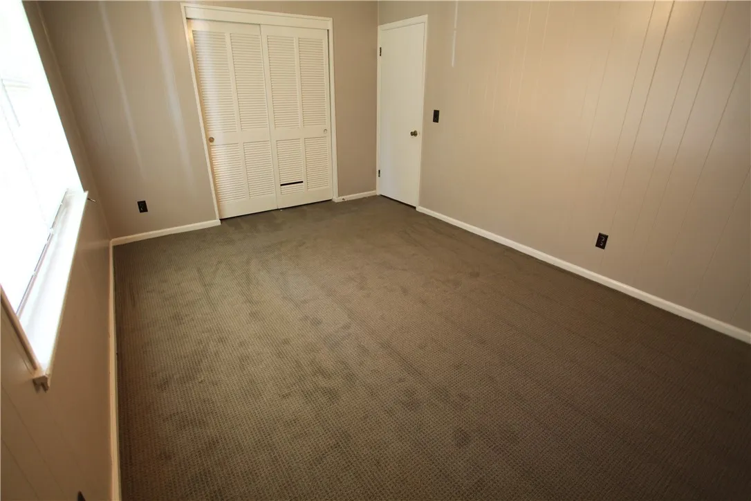 This spacious bedroom offers ample natural light and a neutral palette, awaiting your personal touch.