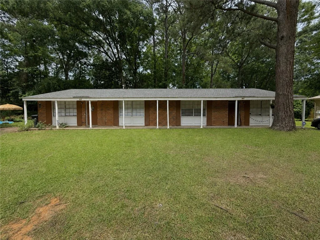 This brick residence offers a welcoming front porch set amidst a verdant lawn.